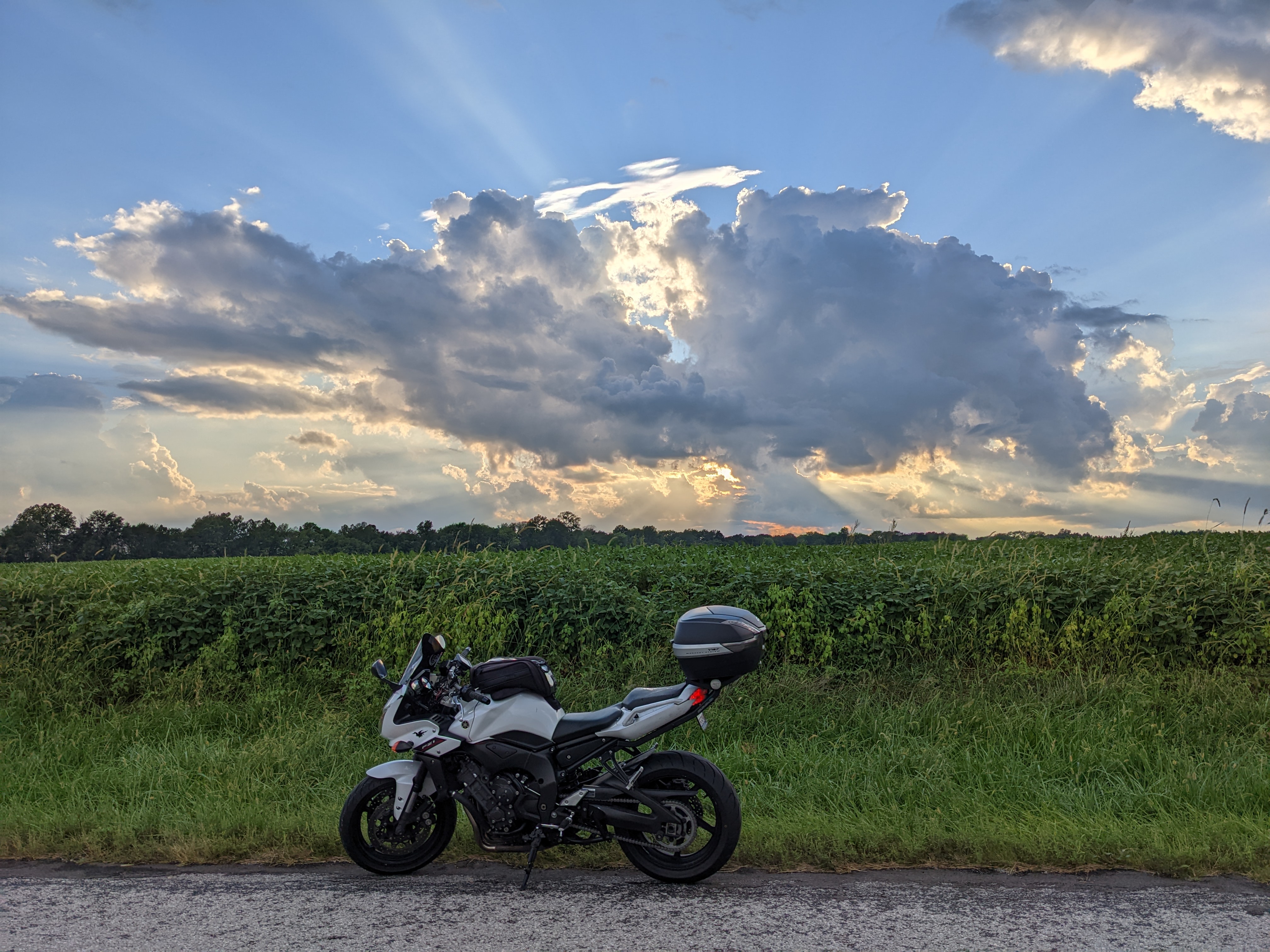 Motorcycle parked at sunset on a remote road